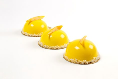 These mango dômes are a bright, tropical work of art to light up the room. Already pre-portioned in individual servings, you can bring them to a brunch or dinner party to steal the show. Further, the glaze and syrup-soaked mango garnish keep the cake fresh so you can prepare this entremet up to two days before serving. Dome Desserts, Entremet Recipe, Mirror Glaze Recipe, Entremet Cake, Chocolate Mirror Glaze, Mango Mousse Cake, Dome Cake, Mirror Glaze Cake Recipes, French Baking