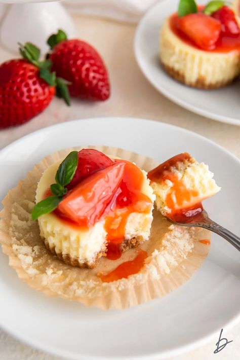 fork taking bite of mini cheesecake with strawberry sauce on paper muffin liner. Whipped Cream Cheesecake, Chunky Monkey Brownies, Easy Mini Cheesecakes, Strawberries And Whipped Cream, Mini Cheesecakes Easy, Cream Room, Oven Temperature, Cream Cheesecake, Muffin Liners