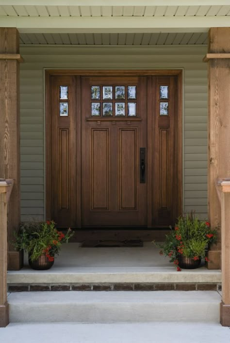 The front door of your home says a lot about who lives inside. But selecting an entry door that fits your home’s style, adds value to your home, and is aesthetically beautiful can be an overwhelming process. Because a front door has the ability to add (or subtract) to our home’s curb appeal as well as safety, replacing it is consistently rated a high-value project for homeowners to invest in. Dark Wooden Front Door, Double Front Doors With Side Lights, Craftsman Style Exterior Doors, Wood Double Front Door, Craftsman Front Door, Craftsman Entry, Craftsman Front Doors, Entry Door With Sidelights, Ranch Remodel