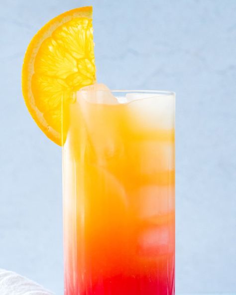 Orange juice, vodka and grenadine layer the colors of a sunrise in the vibrant Vodka Sunrise! Mix up this cocktail to impress. #vodka #vodkasunrise #vodkacocktail #grenadine #orangejuice #orangejuicecocktail #brunchdrink #easycocktail Sunrise Drink, Dinner Party Drinks, Cocktails Made With Vodka, Drinks Vodka, Vodka Orange, Orange Juice Cocktails, Vodka Mixed Drinks, Vodka Sunrise, Orange Juice And Vodka