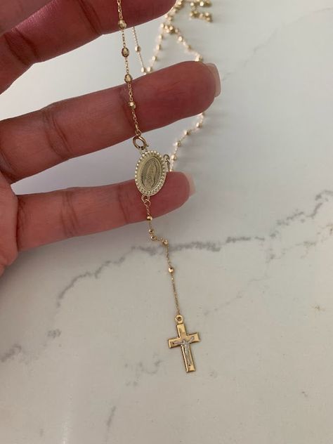 This 14K yellow gold rosary necklace is the perfect religious symbol of faith. Featuring a cross pendant, shiny diamond cut 2.5mm round beads, and a 20” chain, this necklace is a meaningful piece of Catholic jewelry. Its delicate design makes it an ideal gift for anniversaries, confirmations, 1st communion and other special occasions. ♦ Materials: 14K Solid Gold♦ Available colors: Gold ♦ Necklace measurements: 20" total length, beads are 2.5MM♦ Beads measurements: Beads are 2.5MM---------------- Catholic Gold Jewelry, Affordable Gold Spiritual Rosary, Gold Christian Jewelry, Adjustable Yellow Gold Crucifix Jewelry, Dainty Gold Crucifix Jewelry, Gold Crucifix Jewelry Stamped 14k, 14k Gold Filled Beaded Chain Jewelry Gift, Gold Spiritual Jewelry With Beaded Chain, Spiritual Gold Jewelry With Beaded Chain