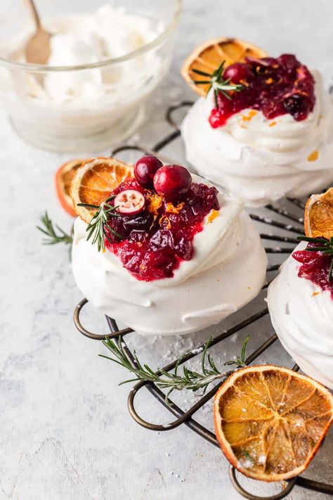 Mini Cranberry Pavlovas combine the crisp outer layer with a soft chewy centre. The meringue is topped with a lightly whipped cream and orange infused cranberry sauce, Light, delicate, crisp, soft, sweet and tangy encapsulate this festive, holiday dessert. By Emma Duckworth Bakes. Cranberry Meringue, Meringue Nests, Mini Pavlovas, Mini Meringues, Cranberry Orange Sauce, Baked Meringue, Meringue Pavlova, Mini Pavlova, Cranberry Cream Cheese