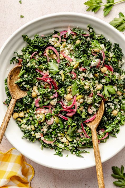 Fresh, herby kale couscous salad with feta, chickpeas, and olives that comes together in just 30 minutes for a satisfying lunch or side dish. Scoop up this beautiful salad with tortilla chips or pitas chips to get an extra delicious crunch! You'll love this veggie-packed salad as is or with your favorite grilled proteins. Ambitious Kitchen Kale Couscous Salad, Kale And Couscous Recipes, Lemon Herb Couscous Salad, Plant Based Salads Healthy, Trendy Salads, Scoopable Salad, Couscous Salad Recipes Cold, Couscous Lunch, Kale Couscous