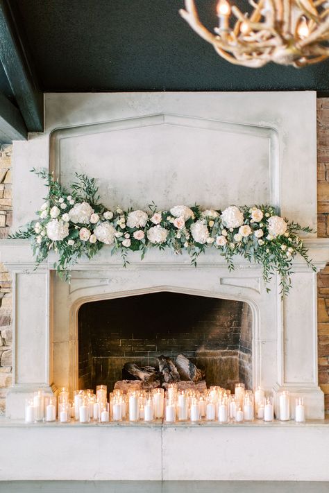 This candlelit, Lake House Calgary wedding was super romantic with lush garden inspired florals on the fireplace mantel. We used BC grown white hydrangea, David Austin White O' Hara garden roses, white lisianthus, white ranunculus and snowflake spray roses. Italian ruscus, olive leaves and seeded eucalyptus were incorporated for pops of green.  Photo: Heidrich Photography  #calgarywedding #lakehousecalgarywedding #flowersbyjanie #whitehydrangeawedding #whiteohararosewedding #whiteandgreenwedding Mantel Floral Arrangements, Wedding Fireplace Decorations, Mantel Flowers, Wedding Mantle, Bronte Bride, Wedding Fireplace, Wedding Arches, Calgary Wedding, Floral Studio