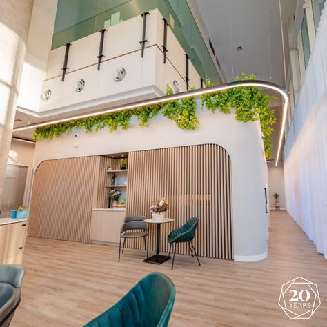 The double-story layout has been seamlessly integrated into the overall design, transforming it into a standout feature rather than a mere utilitarian element. Lush greenery graces the lower level's ledge, amplified by a specially crafted wrap-around LED light that highlights the contours of the structure. #inspiringspaces #healthcaredesign #medicalpratice #interiordesign #interior #fitoutservices #fitout #officedesign #workplaceinteriors #office #medicalclinc White Waiting Room, Story Layout, Healthcare Design, Inspiring Spaces, Waiting Rooms, Overall Design, Lush Greenery, Office Design, Bright White