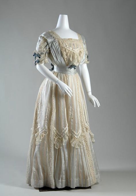 Shogren | An ivory silk gauze dress embellished with with light blue satin stripe, ivory lace, ivory ribbon, and blue velvet ribbon, USA, circa 1904. 1905 Dress, Dress 1900, 1900s Costume, Edwardian Dresses, Gaun Abad Pertengahan, 1900s Fashion, Fashion Through The Ages, Silk And Lace, Edwardian Dress