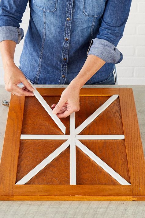 Banish boring kitchen cabinets with DIY farmhouse cabinets that complement your rustic kitchen decor. This easy project employs wood trim to create a barn door-inspired design across the cabinet front. #farmhousediy #farmhousekitchen #kitchencabinet #cabinetideas #bhg Rustic Cabinet Doors, Kitchen Shutters, Diy Farmhouse Kitchen, Barn Door Cabinet, Diy Kitchen Cabinet, Cabinet Door Designs, Rustic Kitchen Tables, Diy Cabinet Doors, Diy Cabinet