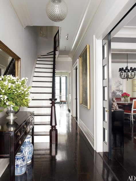 The foyer of Brooke Shields’s New York City townhouse, is furnished with an 1860s Chinese desk adorned with decorative blue-and-white vessels. Townhouse Decorating, Georgiana Design, New York Townhouse, Foyer Staircase, Casa Country, New York Homes, Dark Wood Floors, Foyer Decorating, Foyer Design