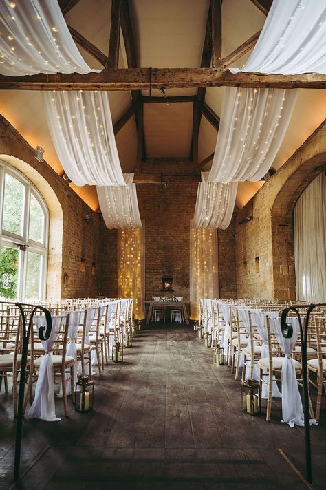 White Gold Wedding Cotswold Pictures Barn Reception Drapes Fairy Lights Decor #wedding #barnwedding Beam Decoration Ideas Wedding, Draping And Lighting Wedding, Ceiling Drapery With Fairy Lights, White Drapery Wedding, Fairy Lights Decor Wedding, Lights Decor Wedding, White Drapes Wedding, Wedding Barn Decorations, Draping Wedding Reception