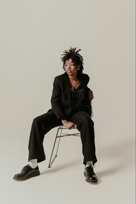 Black woman on locs wearing a suit, sitting on a chair in a studio photoshoot picture. Suits For Women Photoshoot Ideas, Sitting Fashion Poses, Studio Stool Photoshoot, Grad Photo Outfit Ideas, Wooden Stool Photoshoot, Street Style Studio Photoshoot, Chair Modeling Poses, Photoshoot With Locs, Suit Women Photoshoot