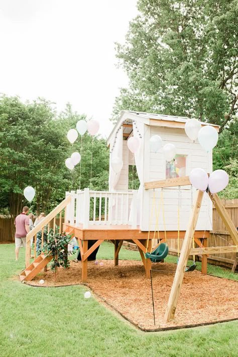 a white kids' playhouse with a porch, a ladder, swings and white balloons is a lovely idea for your garden Play Set Design Ideas, Playhouse In Backyard, Swingset Tree House, Backyard Design With Playset, Backyard Inspiration Kids, Play Set Backyard, Backyard Swingset Area, Backyard Childrens Play Area, Backyard Family Ideas