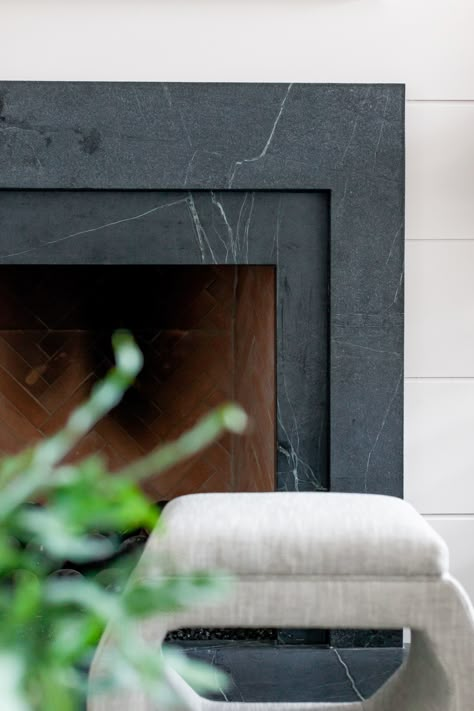 We remodeled this dated fireplace using layered soapstone and wide shiplap. We fell in love with this black, veiny soapstone slab. We also put stools in front of the fireplace for extra seating. Great idea for a fireplace makeover, fireplace design, or fireplace update. Designed by Lark Interiors, Dallas TX Granite Fireplace, Stone Fireplace Surround, Fireplace Tile Surround, Black Fireplace, Interior Design Work, Fireplace Hearth, Fireplace Remodel, Fireplace Surround, Marble Fireplaces