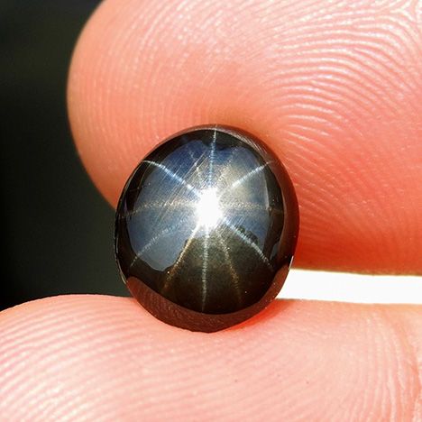 A black star sapphire with one set of golden rays and another set of silver rays. Star Sapphire Stone, Black Sapphire Ring, Black Star Sapphire, Stars Jewelry, Sapphire Eyes, Cats Eyes, Ruby And Sapphire, Stone World, Starry Eyed