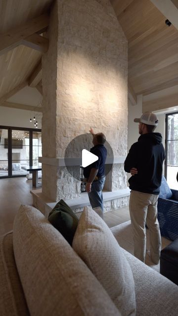 Hendel Homes on Instagram: "Talking with one of our knowledgeable site supervisors on the background behind this custom designed fireplace. Walking into the great room, this feature certainly draws your eye in as you step into the space. Properly executed with quality by @lukebuskermasonry @orijinstone and @glowing_hearth. A limestone feature we love that compliments both the exterior and interior!" Fireplace Bench Ideas, Huge Fireplace High Ceilings, Fireplace Dividing Rooms, Indoor Stone Fireplace, Limestone Fireplace Wall, Fireplace In The Middle Of The Room, Fireplace In Vaulted Living Room, Limestone Entryway, Fireplace Build Out