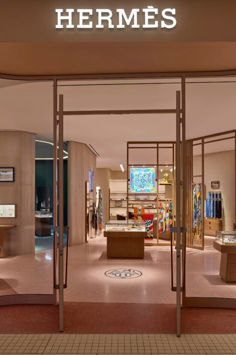 The new Hermès store at Aventura Mall fuses Miami’s unique coastal atmosphere with the luxury fashion house’s French spirit. Customers enter the store through an undulating glass façade, reminiscent of the waves of the sea and framed in metal in a warm shade of pink. Across the threshold, discover all 20 product categories such as leather goods, fine silk scarves, ties, men and women’s ready-to-wear collections, jewelry, fragrance, Art de Vivre, and Art de Table. Visit Hermès at Aventura Mall. Hermes Interior, Aventura Mall, Hermes Store, Fashion Showroom, Hermes Shop, Mall Stores, Store Layout, Store Interiors, Store Windows