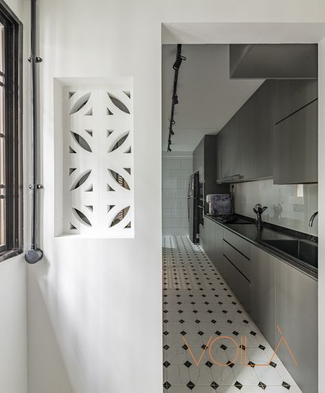 We wanted the kitchen to feel as big as possible so we kept things very simple by opting for white wall tiles and a monochrome dots in tile pattern for the floor. Kitchen cabinets were kept in a sleek grey with a black quartz countertop. We wanted to balance the modern feel of the kitchen with some colonial influences that we drew from the flooring as well as the lattice cutout in the wall at the far end of the kitchen. Black Quartz Countertop, Modern Colonial Kitchen, Service Yard, Ventilation Block, Modern Victorian Style, Breeze Block Wall, Colonial Kitchen, Modern Colonial, Breeze Blocks