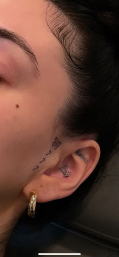 777 Ear Tattoo, Beauty Mark Tattoo Face, Small Face Tattoos For Women By Ear, Cheek Tattoo For Women, Little Face Tattoos, Evil Eye Tattoo Behind Ear, Above Eyebrow Tattoo, Side Ear Tattoo, Tiny Face Tattoos For Women