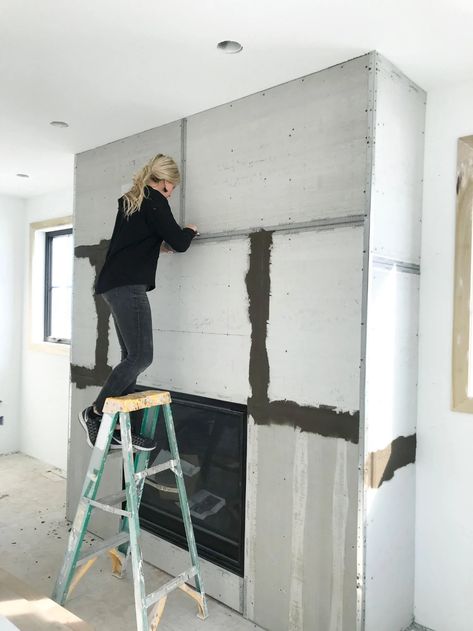 How to DIY a Faux Concrete Fireplace Concrete Skim Coat Fireplace, Cement Smear Fireplace, Cement Fireplace Makeover, Large Cased Openings Between Rooms, Symmetrical Living Room With Fireplace, Plastered Fireplace Ideas, Basement Fireplace Remodel, Dark Fireplace Ideas, Modern Boho Fireplace