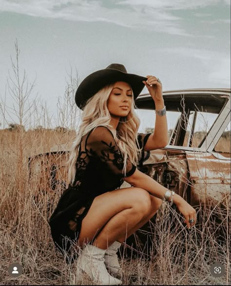 Girl in field, blonde western vibe with black felt cowboy hat and western silver jewelry in black western lace dress and tan cowgirl boots, posed crouched down Country 30th Birthday Photoshoot, Fall Photoshoot Western, Western Female Photoshoot, Cowboy Hat Pictures Photo Shoot, Western Whiskey Photoshoot, Cowgirl Inspired Photoshoot, Vintage 50s Photoshoot, Southern Photoshoot Ideas, Moody Western Photoshoot