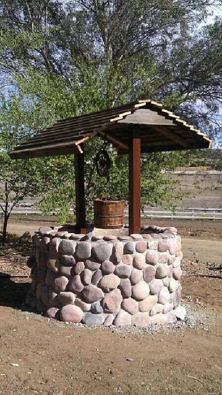 A Do-It-Yourself garden stone wishing well brings many decorative possibilities. Useful for creating a koi pond, a flower well, or tool shed. How To Build A Stone Wishing Well, Rock Wishing Well, Wooden Well With Flowers, Well Decoration Ideas, Well Design Ideas, Water Well Design, Wishing Well Diy, Stone Wishing Well, Water Well House