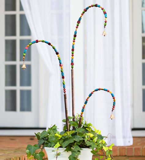 Add height, color and sound to your yard with our Beaded Garden Stake with Bell. This unique accent creates visual interest in garden, flower bed or planter.Textured, painted resin beads highlight the design with a metal bell to chime in the breeze. Handmade in Bali, this decorative garden stake is sure to bring peace and tranquility wherever you display it. Use one or group several together to increase the impact.Metal stake with bendable wire frame. Size is approxima Handmade Garden Decorations, Fairy Garden Stakes, Flowers Backyard, Bell Gardens, Gardening Decor, Bohemian Garden, Plant Stakes, Decorative Garden Stakes, Fairy Wands