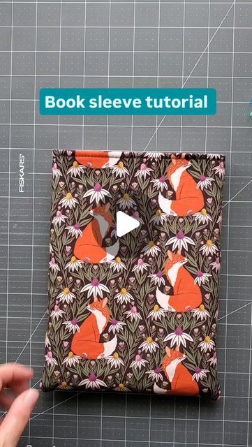 Muriel Corbierre on Instagram: "Finished size: about 7.5" wide by 10" tall (19cm wide by 25.5cm tall). This fits medium books (6"×9") and probably some e-readers.  I used quilting cotton and fusible fleece. Some people use foam interfacing, but I think it's too expensive for a book sleeve but it would be a good idea for an e-reader. I will do another reel this week to show you how to add an elastic and button closure. Cut 2 each of exterior, lining and fusible fleece: 10.5" tall by 8" wide (27cm tall by 20cm wide). Seam allowance is 1/4" (6mm). I have some tentative pocket book fabric dimensions but I need to test them first. Coming up later this week too! Happy sewing!" Book Pouch Sewing Pattern Free, Diy Fabric Book Sleeve, Book Sleeves Sewing Pattern, How To Sew A Book Cover, Quilted Book Sleeve Pattern, Kindle Pouch Diy Free Pattern, Diy Book Sleeve Free Pattern, Book Sleeve Pattern Free, Kindle Case Sewing Pattern