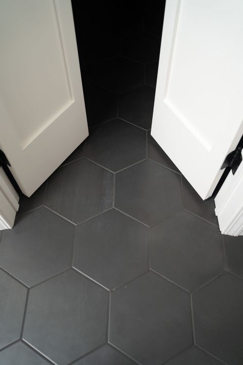 Black Hexagon Tile Bathroom Black Grout, Black Hexagon Tile Floor Laundry Room, Black Tile Guest Bathroom, Charcoal Gray Bathroom Floor, Black Hexagon Tile Black Grout, Black Hexagon Tile Bathroom Floor With Wood Vanity, Black Hexagon Tile Grout Color, Black Tile Black Grout Bathroom, Grey Honeycomb Tile Bathroom