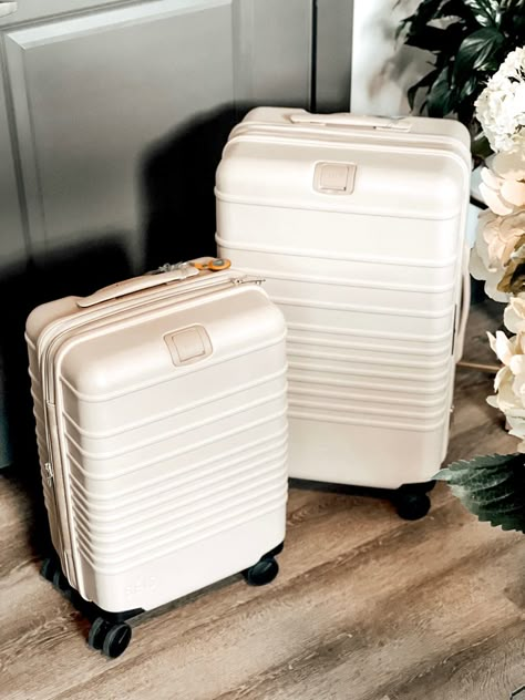 Set of beige rolling spinner luggage and apple AirTag charm. White Luggage Set, Small Luggage Suitcases, White Suitcase Aesthetic, Cute Carry On Luggage, Cute Luggage Sets, Teen Luggage, White Suitcase, Cute Suitcase, White Luggage