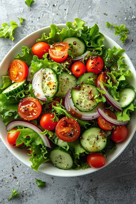 Overhead view of a colorful Mixed Greens Salad bowl filled with a variety of fresh lettuce, ripe cherry tomatoes, crisp cucumber slices, and slivers of red onion, all lightly coated with a zesty homemade dressing, showcasing a healthy and appetizing option. Garden Salad Recipe, Low Calorie Salad, Easy Salad Dressing, Leafy Green Salads, Low Carb Salad, Garden Salad, Healthy Food Dishes, Idee Pasto Sano, Healthy Salad