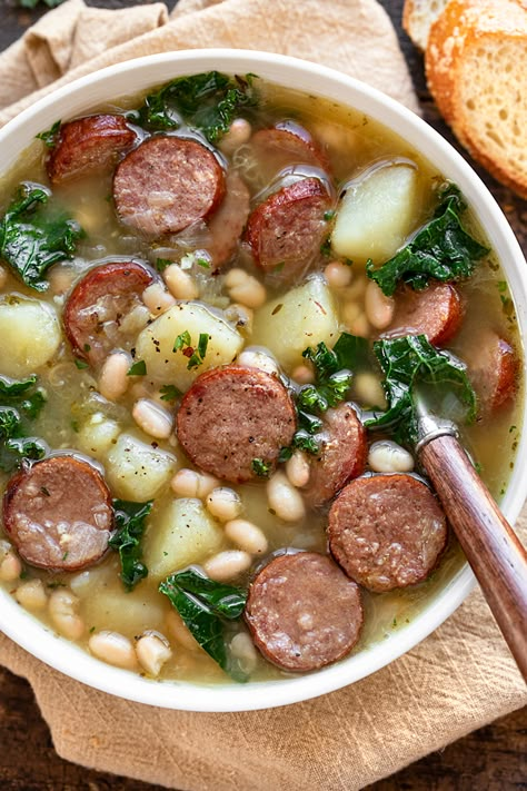 This sausage soup is rich and cozy, brimming with hearty ingredients such as beef smoked sausage, diced potatoes, white beans and kale! | thecozyapron.com #sausagesoup #sausagesouprecipes #sausagesouphealthy Souper Sunday, White Bean And Sausage Soup, White Bean Sausage Soup, Beef Smoked Sausage, White Bean And Sausage, Beans And Kale, Kale White Bean, Bean And Sausage Soup, Pasti Fit