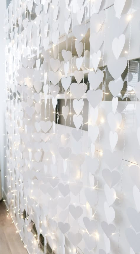 White Party Photo Backdrop, Easy Bridal Shower Photo Backdrop, Heart Backdrop Ideas, White Valentines Aesthetic, White Backdrop Ideas, Simple Engagement Party Decorations, Picture Backdrop Ideas, Garland Photo Backdrop, White Photo Backdrop