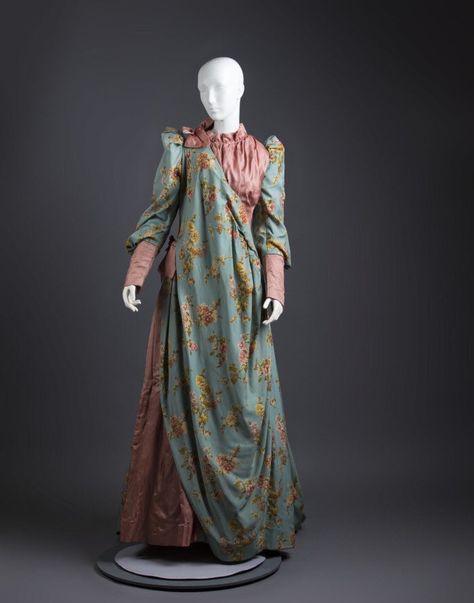 Tea gown, 1870/80, unknown maker. Texas Fashion Collection, UNT College of Visual Arts + Design digital library. They say: “Formal tea gown of green print cotton in multicolored floral print ... pink satin cuffs, bodice and tucks at side. Watteau pleats down center back. ... Lined in olive green polished cotton.” #fashionhistory #victorian #teagown #floral #historicalfashion #historicaldress #victorianfashion #19thcentury #fashion #researchingtheromance Edwardian Tea Gown, Reform Dress, 19th Century Dress, 1870s Fashion, Oc Clothes, Texas Fashion, 19th Century Clothing, Tea Gown, University Of North Texas