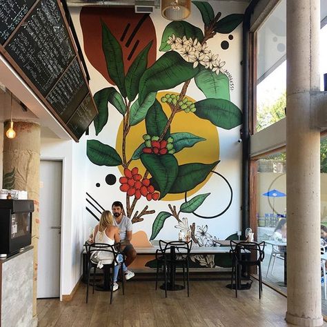 Una locura de lindo @cigalocafe Hormigón a la vista, muchos ventanales por donde entra una luz espectacular, toques de madera y negro con un mural lleno de fuerza y frescura de @danalessi ✨ El café Mural Cafe, Interior Murals, Wall Paint Designs, Murals Street Art, Coffee Shop Design, Cafe Wall, Mural Wall Art, Mural Painting, Cafe Design