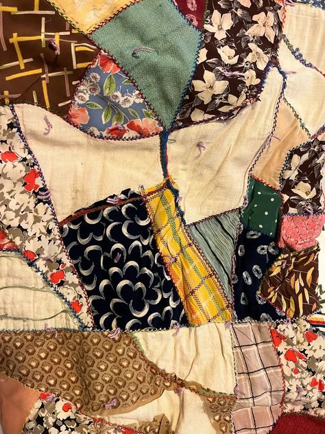 Close up of another vintage crazy quilt made from silks; Crazy quilts have asymmetrical designs, vibrant colors, and intricate stitching patterns. Originating in the late 19th century as a rebellion against the rigid rules of traditional quilting, this unique art form allows quilters to unleash their imagination and showcase their individuality through a patchwork of fabrics. Vintage Crazy Quilts, How To Crazy Quilt, Vintage Scrap Quilts, How To Make A Crazy Quilt, Crazy Quilts Patterns Templates, Scrappy Patchwork Quilts, Crazy Quilt Patterns, Unique Quilt Patterns, Crazy Quilt Templates