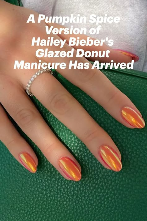 Orange almond-shaped nails holding a green purse Orange Glazed Donut Nails, Glazed Pumpkin Nails, Burnt Orange Glazed Nails, Hailey Bieber Orange Nails, Orange Hailey Bieber Nails, Glazed Donut Nails Orange, Fall Iridescent Nails, Glazed Orange Nails, Iridescent Orange Nails