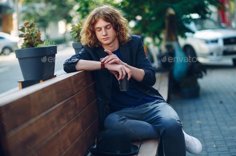 Checking Watch Pose, Goa Men, Pose Ref Photo, Man Sitting On Bench, Man Drinking Coffee, Bench Photography, Hair With Hat, Man With Curly Hair, Wearing Jacket