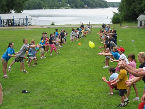 Summer Camp Enjoying A Game Of Water Balloon Toss Water Balloon Toss Game, Waterballoon Toss, Adult Field Day Activities, Water Balloon Toss, Family Field Day, Camping Games For Adults, Water Balloon Games, Fun Easter Games, Camp Games