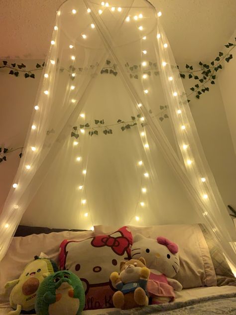 A white canopy above my bed. There are also spherical warm-white lights hanging on it. Lights Over Bed Hanging, Net Canopy Over Bed, Floral Bed Rooms, Canopy With Vines And Lights, Canopy With Fairy Lights, Canope Bed, Canopy Above Bed, Things To Hang Above Bed, Mesh Bed Canopy