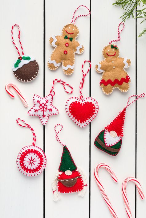 Handmade Felt Christmas Ornaments on a wood table Easy Felt Christmas Ornaments, Christmas Felt Crafts, Diy Felt Ornaments, Diy Felt Christmas, Felt Ornaments Diy, Felt Christmas Tree Decorations, Diy Felt Christmas Ornaments, Christmas Signs Diy, Felt Craft Projects