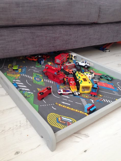 Under the sofa car tray/play mat made from an old over the cot nappy changer. Painted in Paris Grey. Creative toy storage. Livingroom Toys, Living Room Storage Ideas For Toys, Storage Ideas For Toys, Toy Organization Living Room, Living Room Storage Ideas, Creative Toy Storage, Living Room Toy Storage, Baby Play Areas, Baby Toy Storage