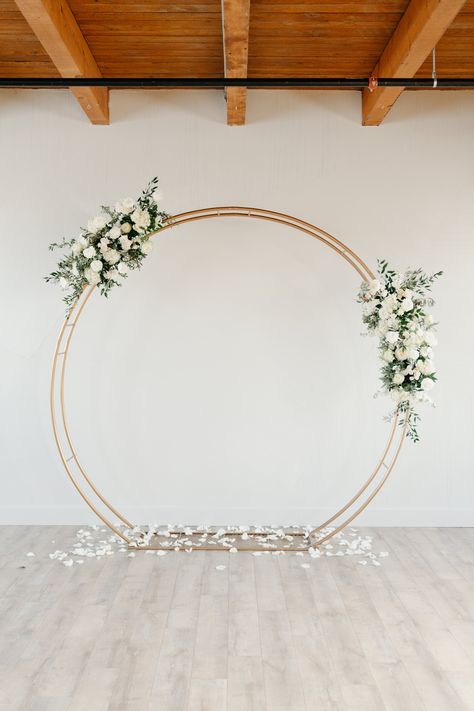 A January wedding never looked so good! Kristen and Ren kept things light and bright with a wildflowery white mix of peonies, roses, ranunculus, dubium, blanched ruscus, and genestra. Olive branches added a sage-colored softness to the overall look. At the altar, asymmetrical clusters of flowers on a minimalist gold wedding arch kept the focus where it should be: on Kristen and Ren’s new life together. Gold Arch Wedding Ceremony, Minimalist Arch Wedding, Minimalist Wedding Altar, White Green Wedding Flowers, Vow Renewal Decor, Simple Wedding Ceremony, Simple Wedding Arch, Ceremony Alter, Gold Wedding Arch