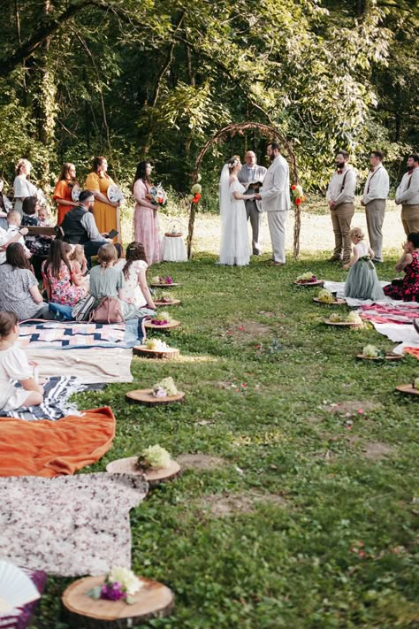 Outdoor Wedding with blanket and wooden chair seating for guests. Wooden slabs for bridal party entrance. 
Wedding arch made out of sticks. Colorful summer wedding. Bridesmaids alternatives, bouquet Bridesmaids holding wicker fan. Groomsmen in suspenders. Rainbow colors for wedding. Wedding Seat Ideas Outdoor, Picnic Style Wedding Ceremony, Picnic Blanket Wedding Ceremony, Small Park Wedding Ideas, Picnic Ceremony Wedding, Simple Picnic Wedding, Picnic Blanket Wedding Seating, Wedding Picnic Blankets, Blanket Seating Wedding