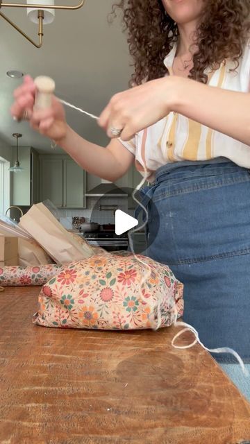 Sarah on Instagram: "Mother’s Day loaf wrapping, but make it floral!   Wearing my @ballerinafarm apron! Love it so much 🤎  #microbakery #sourdoughmicrobakery #organicmicrobakery #homestead #sustainable #sourdough #organicbread #organicgoods #bread #ovenspring #shaping #organicsourdough #baguette #organicbaguette #shaping #breadshaping #farmhouse #farm #homestead #ovenspring #puttingthebreadtobed #slowliving #bakeryviews #slowdown  #mothersday #gifting" How To Wrap Loaf Of Bread, Artisan Bread Wrapping Ideas, How To Wrap Bread As A Gift Basket Ideas, Bread As Gifts Holidays, Apron Gift Wrapping Ideas, Gift Wrapping Bread Loaves, Wrapping Homemade Bread Gift Ideas, Bread Loaf Wrapping Ideas, How To Gift Wrap A Round Loaf Of Bread