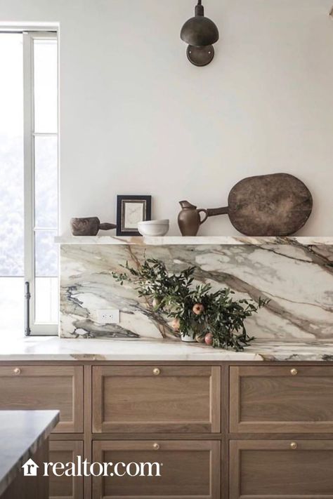 Marble backsplashes instantly elevate any kitchen. It can work with sleek, modern kitchens or more traditional ones. Choose darker veining or lighter depending on the look and feel you are going for. Don’t have a massive budget for marble? Turn to quartz. t’s the closest thing to marble that I’ve seen on the market, and is durable, stain-resistant, and cost-effective. Most Popular Kitchens, Marble Backsplash Kitchen, Popular Kitchen Designs, Quartz Backsplash, Countertop Backsplash, Quartz Kitchen, Popular Kitchens, Marble Backsplash, Kitchen Cabinet Hardware