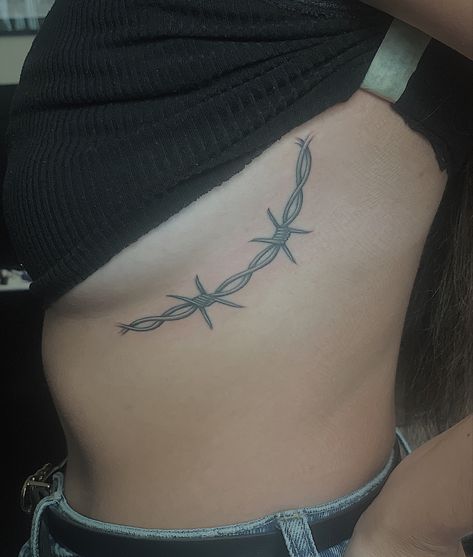 barbed wire tattoo around the side of the breast Spine Tattoos Barbed Wire, Longhorn Barbed Wire Tattoo, Barbed Wire Rib Tattoo, Tattoo Ideas Female Behind Elbow, Barbed Wire Hip Tattoo, Fine Line Barbed Wire Tattoo, Western Barbed Wire Tattoo, Bard Wire Tattoos, Barbwire Tattoo Around Thigh