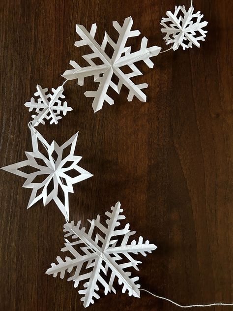 How to Make Paper Snowflake Garland for Christmas; Paper Cutout Snowflakes, Snowflake Paper Garland, Hanging Paper Snowflakes From Ceiling, How To Make Paper Snowflake Garland, Snow Flake Garland Diy, Paper Snowflakes From Ceiling, Easy Christmas Snowflakes, Window Snowflakes Diy, Make Your Own Snowflakes