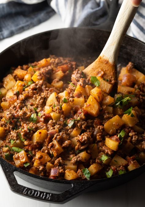 Wooden spoon stirring in the chopped parsley. Ground Sausage Potato Recipes, Nourishing Ground Beef Recipes, Ground Beef Potato Carrot Recipe, Ground Beef Stuffed Potatoes, Ground Beef Potatoes Skillet, Ground Beef And Tomato Recipes, Spicy Ground Beef Recipes, Potato Ground Beef Recipes, Potatoes And Ground Beef Recipes