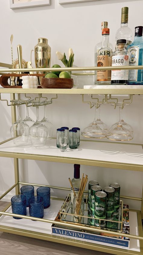 It’s best to choose colors that tie throughout your apartment when designing your bar cart. Tequila Bar Cart, Bar Cart Colorful, Bar Cart Must Haves, Bar Cart Styling Without Alcohol, Classy Bar Cart, College Bar Cart, Blue Bar Cart, Cute Bar Cart, Bar Cart Aesthetic