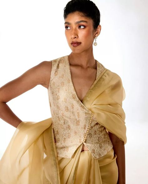 Old-world grandeur, combined with modern-day effortlessness. The light gold Triveni saree perfectly complements our delicately rose-patterned meenakari brocade blouse, crafted in a contemporary waistcoat style silhouette. Jewelry courtesy: @thehouseofrose #Tilfi #TilfiSarees #TilfiIcons Saree Product Shoot, Gold Saree Blouse, Waistcoat Style, Long Blouses, Brocade Blouse Designs, Meena Bazaar, Silhouette Jewelry, Floral Saree, Traditional Blouse Designs