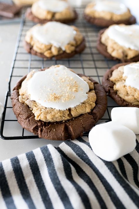 smores brownie cookies on a black cookie cooling rack with large marshmallows in the frame Crumbl Cookie Copycat Smores Brownie, Crumbl Cookie Smores, Smores Crumbl Cookies, Smores Brownie Cookies, Double Fudge Brownie Crumbl Cookies, Smores Crumble Cookie Recipe, Crumbl Cookie Copycat Smores, Smores Crumble Cookie, Cool Cookie Recipes